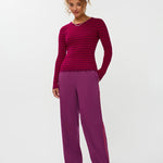 Model draagt de ydence knitted top devina met fuchsia en rode strepen.