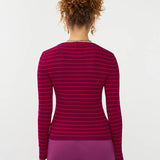 Model draagt de ydence knitted top devina met fuchsia en rode strepen.