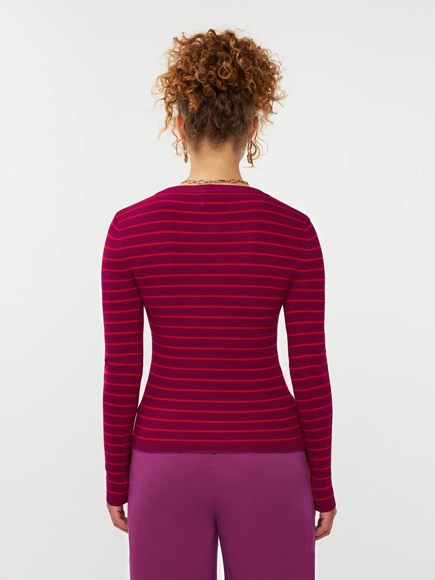 Model draagt de ydence knitted top devina met fuchsia en rode strepen.