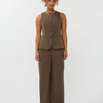 model draagt het mellie gilet van ydence in de kleur mud met de yade pants als co-ord set.
