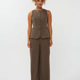 model draagt het mellie gilet van ydence in de kleur mud met de yade pants als co-ord set.