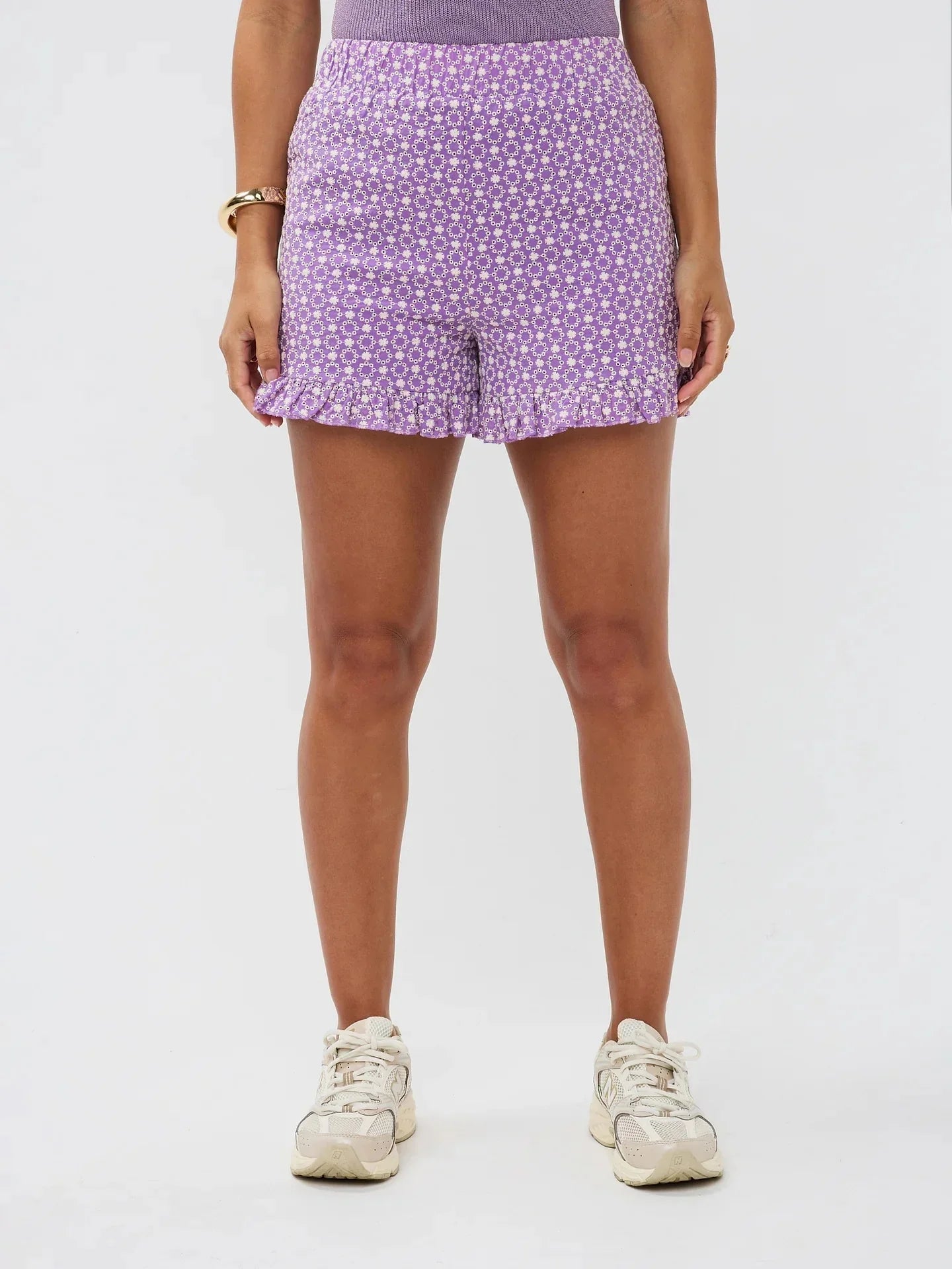 Model draagt de Larissa short, een paarse luchtige short met wit bloemenpatroon en rucherand van Ydence.