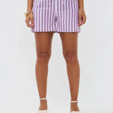 Model draagt de Mima short, een lila-wit gestreepte linnen short met strikceintuur van Ydence.