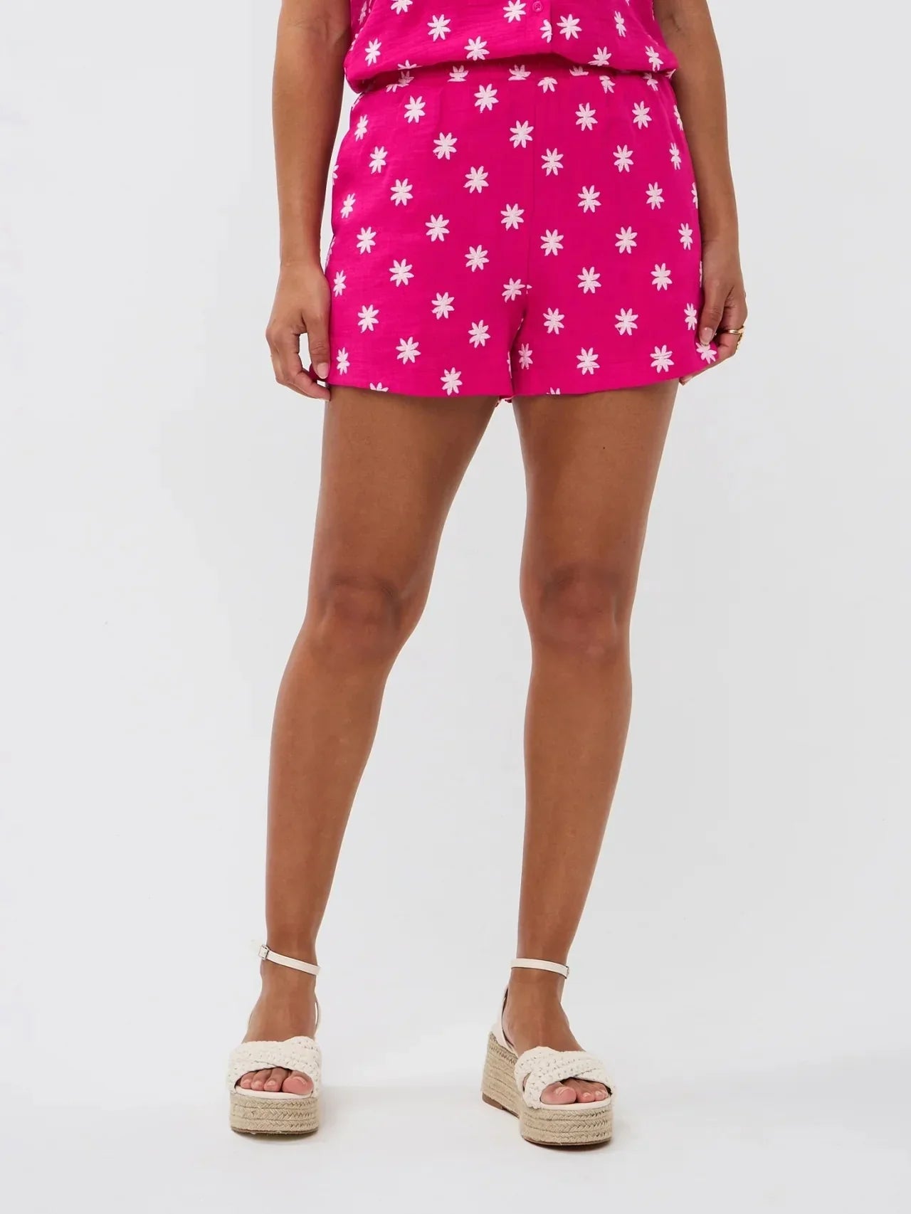 Model draagt een felroze short met witte bloemetjes van Ydence, perfect voor de zomer.