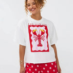 Model draagt het Ydence T-shirt met lobster print, gecombineerd met een rode short met witte bloemetjes.