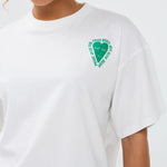 Model draagt het casual Ydence T-shirt More Amore met kleurrijke backprint en groene short met witte streepjes.