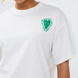 Model draagt het casual Ydence T-shirt More Amore met kleurrijke backprint en groene short met witte streepjes.