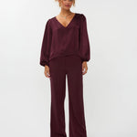 modelfoto van de solange pants van ydence in burgundy met een zelfde kleur blouse erop gecombineerd.