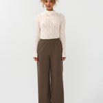 Model draagt de ydence yade pants in de kleur mud met een witte top.