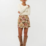 Model draagt de violette skort van ydencemet bloemenprint  onder een witte top.