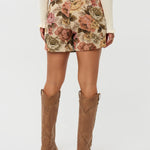 Model draagt de violette skort van ydencemet bloemenprint, achter zijde.