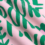 Detailopname van de roze en groene print op het T-shirt.