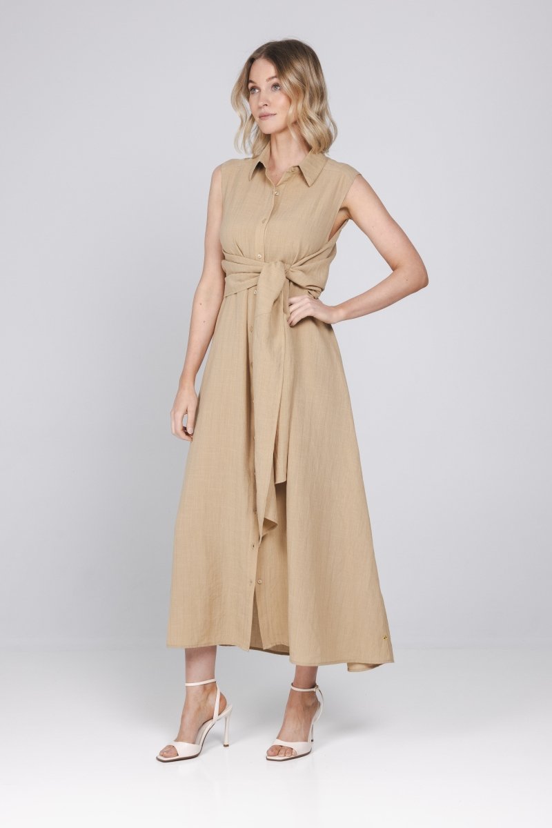 Een model poseert in een studio met een lichtgrijze achtergrond | Accentil Diva Dress Sand | Jo&Co Club