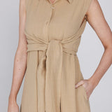 Een close-up van een model dat een mouwloze, zandkleurige jurk draagt | Accentil Diva Dress Sand | Jo&Co Club