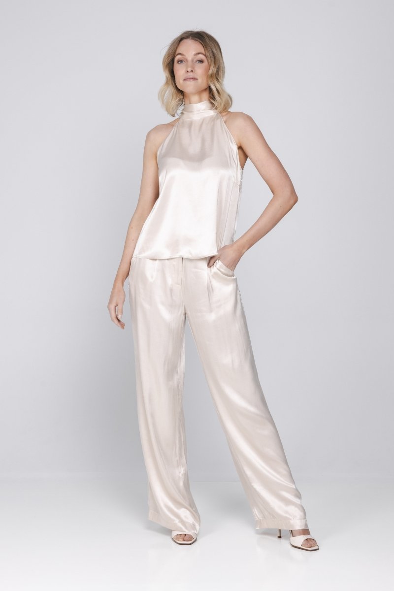 Een model toont een tweedelige, satijnen set in een lichte, champagne-roze | Accentil Flore Top Satin Pink | Jo&Co Club