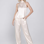 Een model toont een tweedelige, satijnen set in een lichte, champagne-roze | Accentil Flore Top Satin Pink | Jo&Co Club