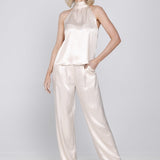 Een model toont een tweedelige, satijnen set in een lichte, champagne-roze | Accentil Flore Top Satin Pink | Jo&Co Club