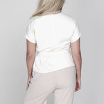 Een model, van achteren gefotografeerd, draagt een off-white blouse met | Accentil Jasmin Blouse Off White | Jo&Co Club