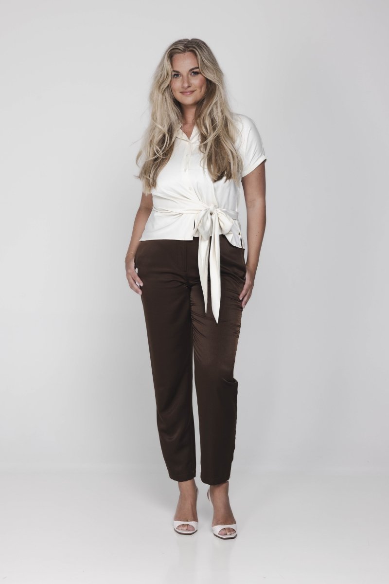 Een model met lang, golvend blond haar poseert tegen een witte achtergrond | Accentil Jasmin Blouse Off White | Jo&Co Club