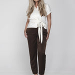 Een model met lang, golvend blond haar poseert tegen een witte achtergrond | Accentil Jasmin Blouse Off White | Jo&Co Club