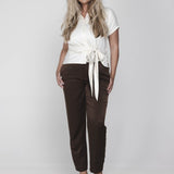 Een model met lang, golvend blond haar poseert tegen een witte achtergrond | Accentil Jasmin Blouse Off White | Jo&Co Club