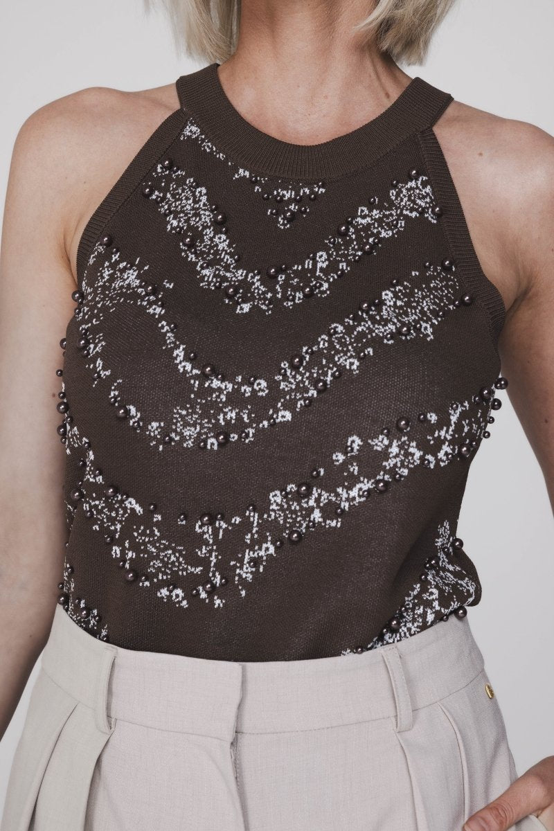 Een close-up foto van een model dat een donkerbruine, mouwloze haltertop draagt | Accentil Jolie Top Espresso | Jo&Co Club