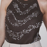 Een close-up foto van een model dat een donkerbruine, mouwloze haltertop draagt | Accentil Jolie Top Espresso | Jo&Co Club