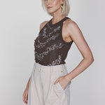 Een model met een korte blonde bob wordt in een driekwart pose getoond tegen een | Accentil Jolie Top Espresso | Jo&Co Club