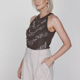 Een model met een korte blonde bob wordt in een driekwart pose getoond tegen een | Accentil Jolie Top Espresso | Jo&Co Club