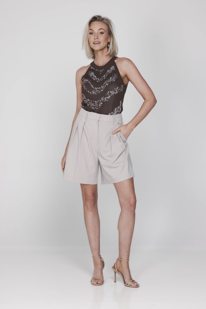 Een model wordt volledig in beeld gebracht tegen een egale, lichte achtergrond | Accentil Jolie Top Espresso | Jo&Co Club