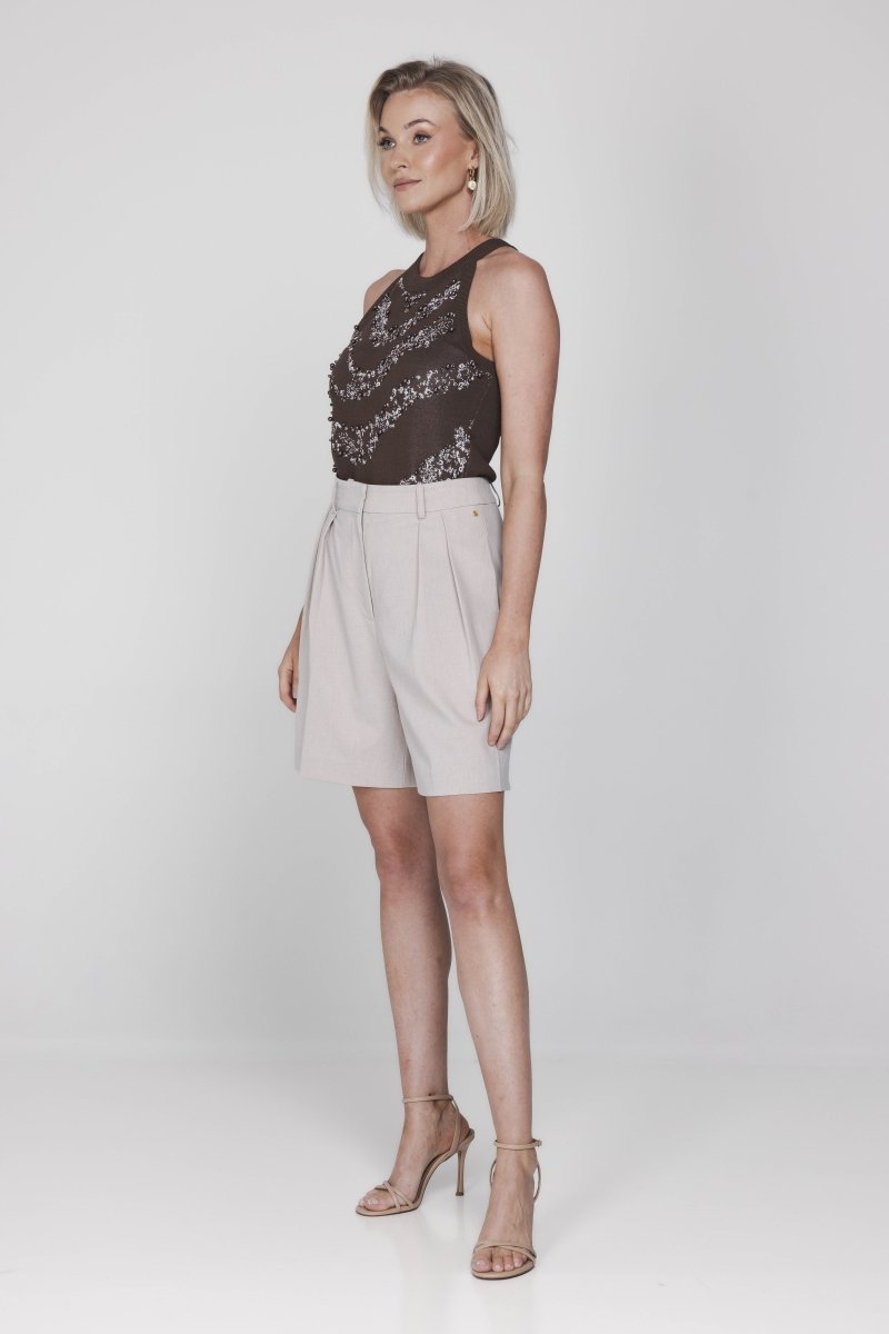 Een model presenteert een complete outfit, bestaande uit een donkerbruine | Accentil Jolie Top Espresso | Jo&Co Club