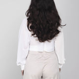 Een model, van achteren gefotografeerd, draagt een cropped witte blouse met | Accentil Kira Blouse Off White | Jo&Co Club