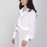 Een model, gepositioneerd in een driekwart aanzicht, draagt een gebroken witte | Accentil Kira Blouse Off White | Jo&Co Club