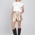 Een model presenteert een volledige outfit tegen een lichtgrijze achtergrond | Accentil Lore Short Sand | Jo&Co Club