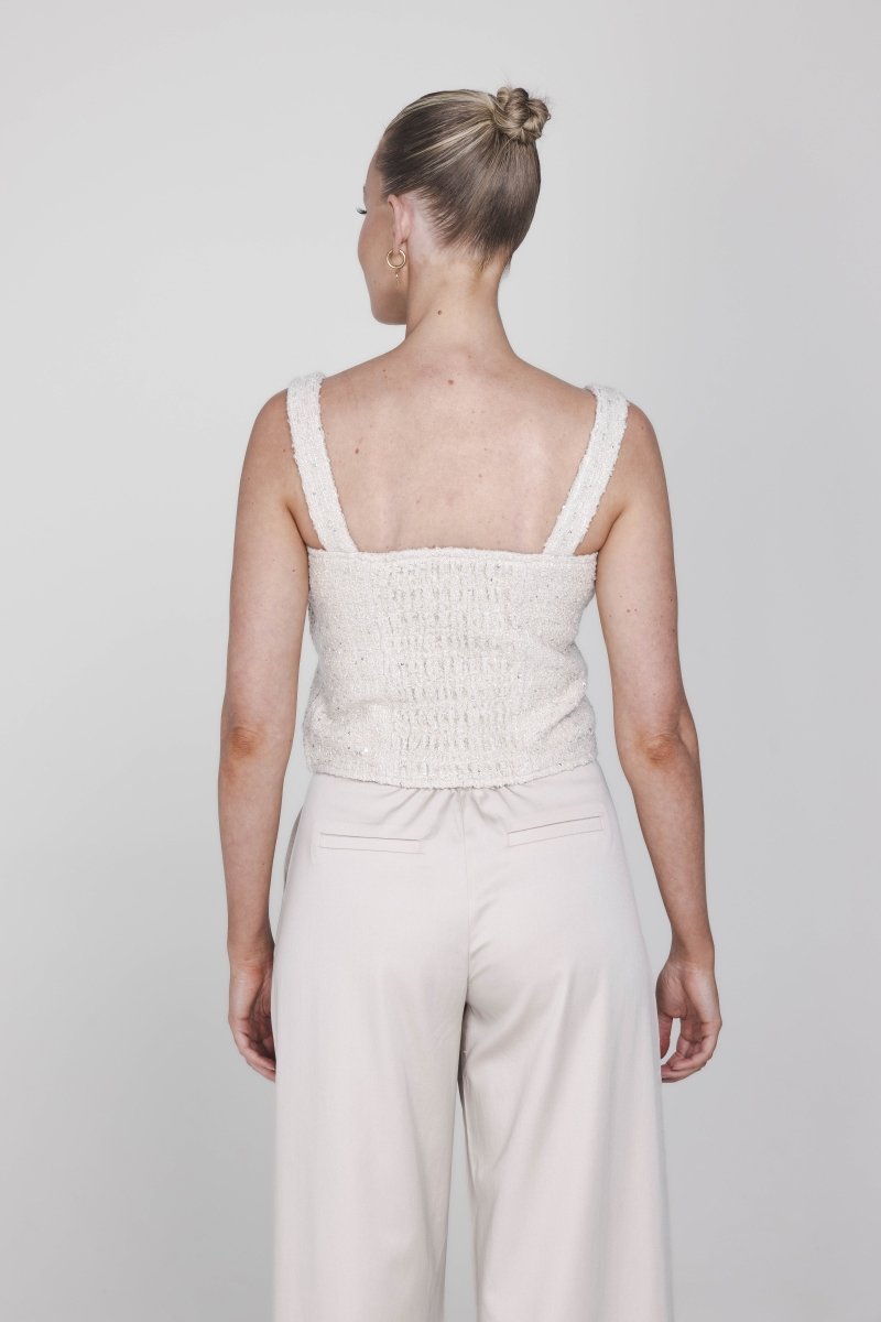 Een model wordt van achteren gefotografeerd tegen een effen, lichtgrijze | Accentil May Top Dolce Beige | Jo&Co Club