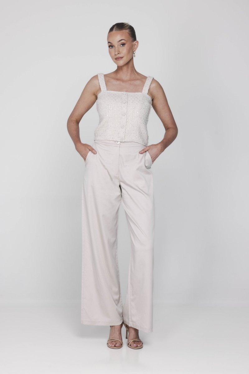 Een model poseert frontaal tegen een lichte, egale achtergrond in een monochrome | Accentil May Top Dolce Beige | Jo&Co Club
