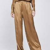 Een model, gefotografeerd vanaf de borst, draagt een complete set in een glanzende | Accentil Mira Pants Mokka | Jo&Co Club