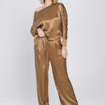 Een model toont een complete look, bestaande uit een glanzende, mokkakleurige top | Accentil Mira Pants Mokka | Jo&Co Club