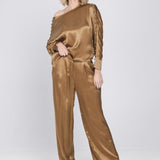 Een model toont een complete look, bestaande uit een glanzende, mokkakleurige top | Accentil Mira Pants Mokka | Jo&Co Club