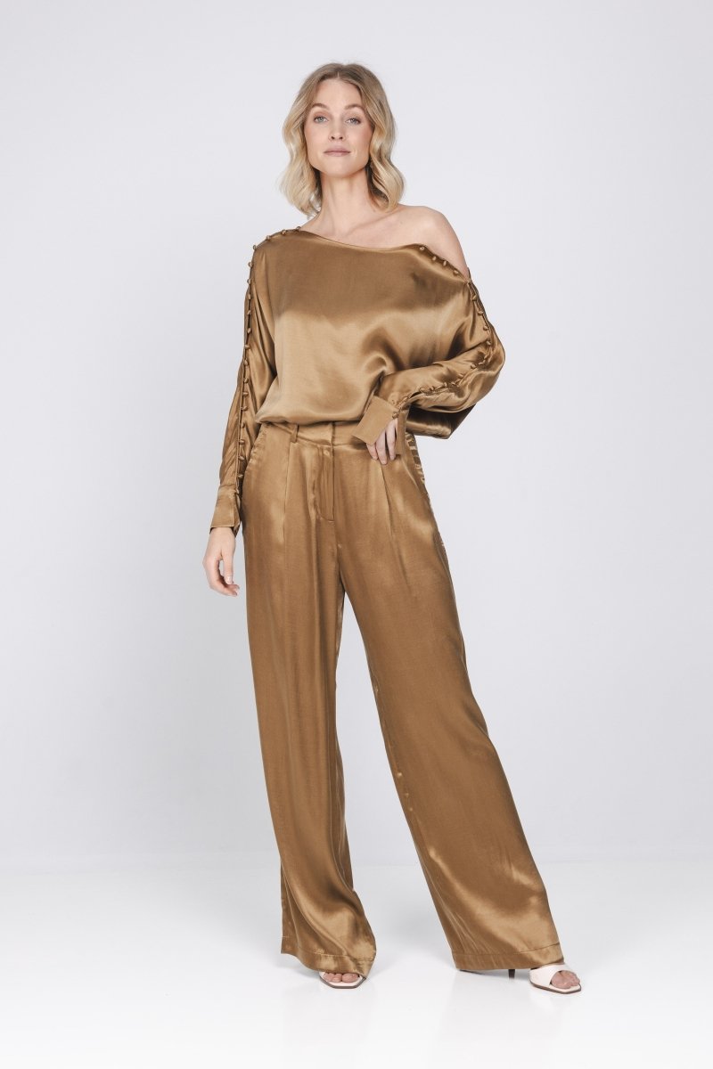 Een model, van top tot teen gefotografeerd, draagt een tweedelige set in een | Accentil Moda Blouse Mokka | Jo&Co Club
