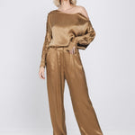 Een model, van top tot teen gefotografeerd, draagt een tweedelige set in een | Accentil Moda Blouse Mokka | Jo&Co Club