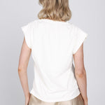 Een model, van achteren gefotografeerd, draagt een gebroken witte top met kapmouwen | Accentil Nivi Top White | Jo&Co Club