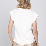Een model, van achteren gefotografeerd, draagt een gebroken witte top met kapmouwen | Accentil Nivi Top White | Jo&Co Club