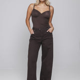 Model in bruine wijde jeans Accentil Minae met donkerbruine body, voorkant | Jo&Co Club