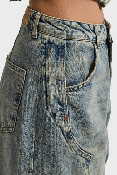 Detailopname van de vintage wassing en de werkzak op de dij van de barrel jeans | Jo&Co Club