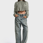 Model draagt de lichtblauwe barrel jeans met een geruite blouse | Jo&Co Club