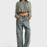 Model draagt de lichtblauwe barrel jeans met een geruite blouse | Jo&Co Club