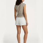 Model van achteren met beige glanzende top en witte textuur short | Jo&Co Club
