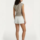 Model van achteren met beige glanzende top en witte textuur short | Jo&Co Club