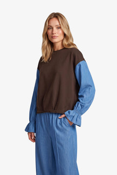 Bruine sweater met blauwe colourblock-mouwen, vooraanzicht | Fluresk Eli sweater | Jo&Co Club